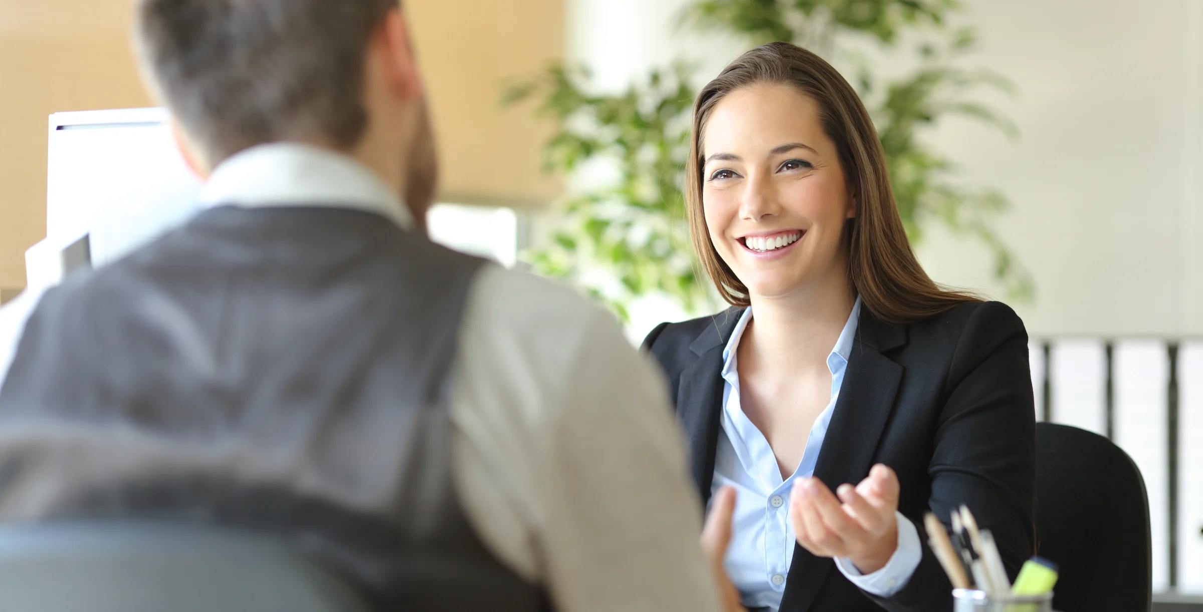 Happy executive coworkers laughing and talking at the office