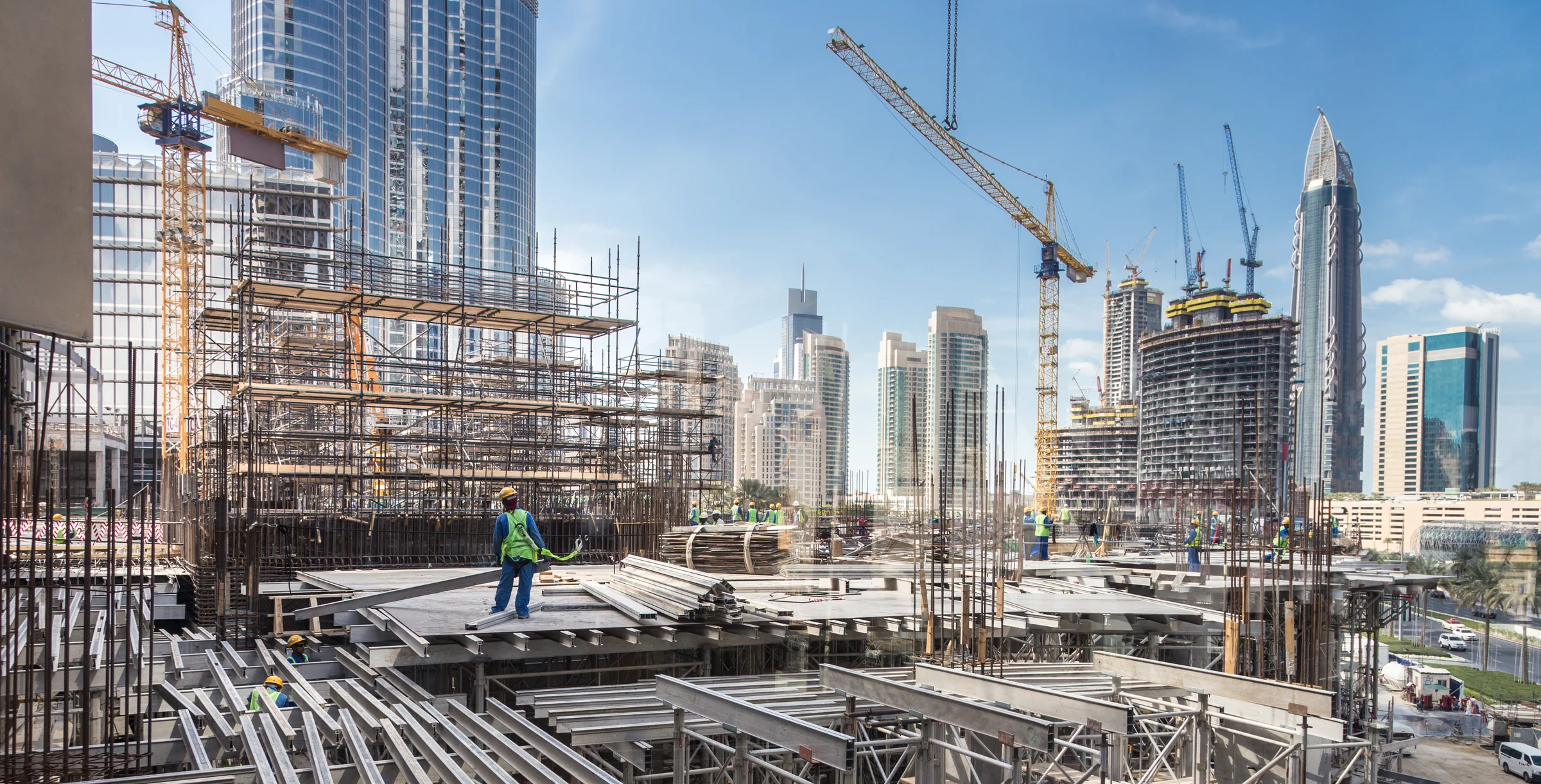 Laborers working on modern constraction site works in Dubai. Fast urban development consept
